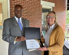 Dr.Wubah presenting Bridget with certificate